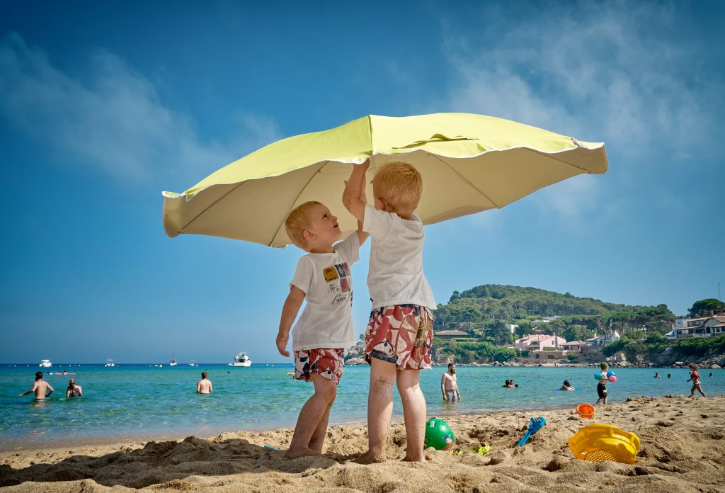 kids fixing beach umbrella