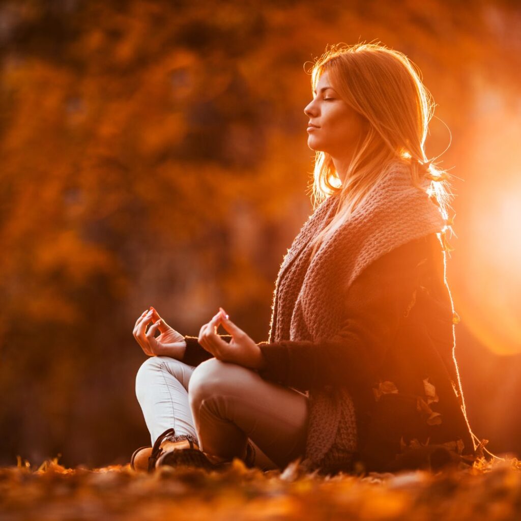 Woman sitting on ground meditating