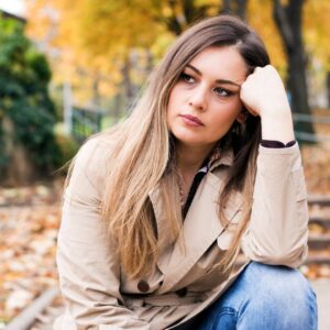 Woman sitting on bench in park thinking