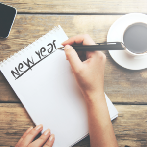 Woman writing new year on paper