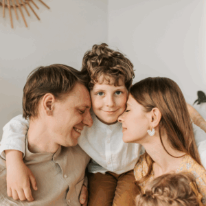 Child with arms around father and mother