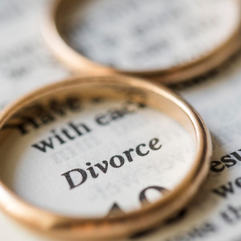 Divorce typed on a paper with rings laying over it.