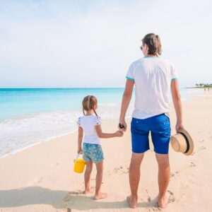 Parent and child walking on beach